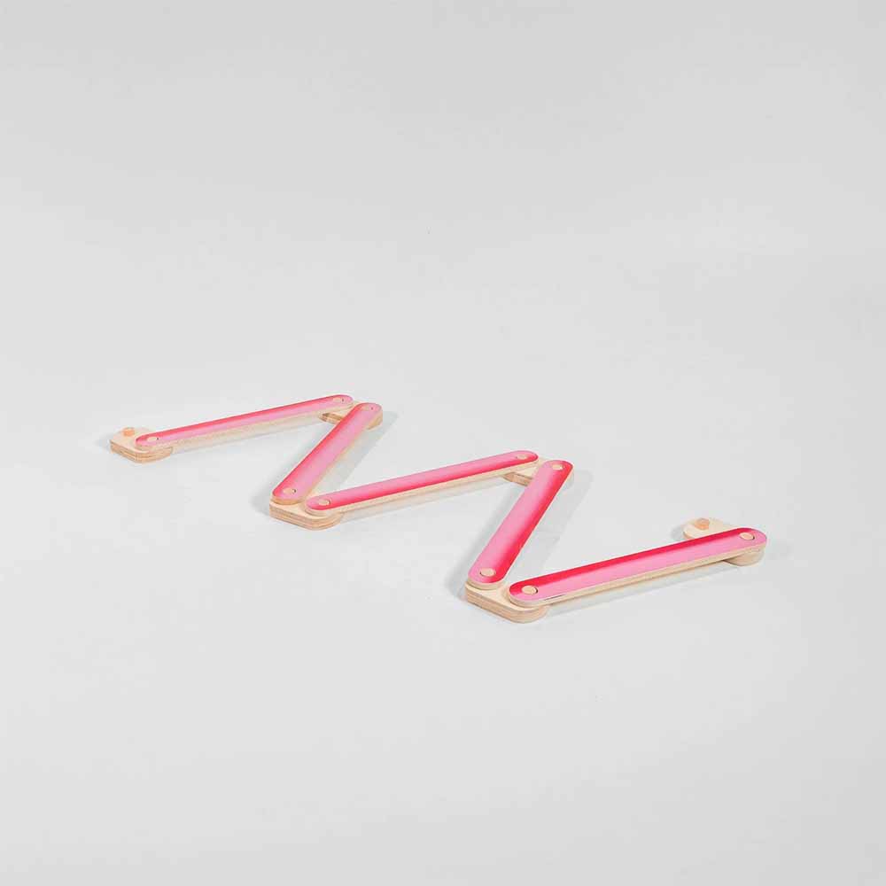 Pink hued balance beam on a light gray background