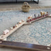 Wooden balance beam set with animals on a patterned rug