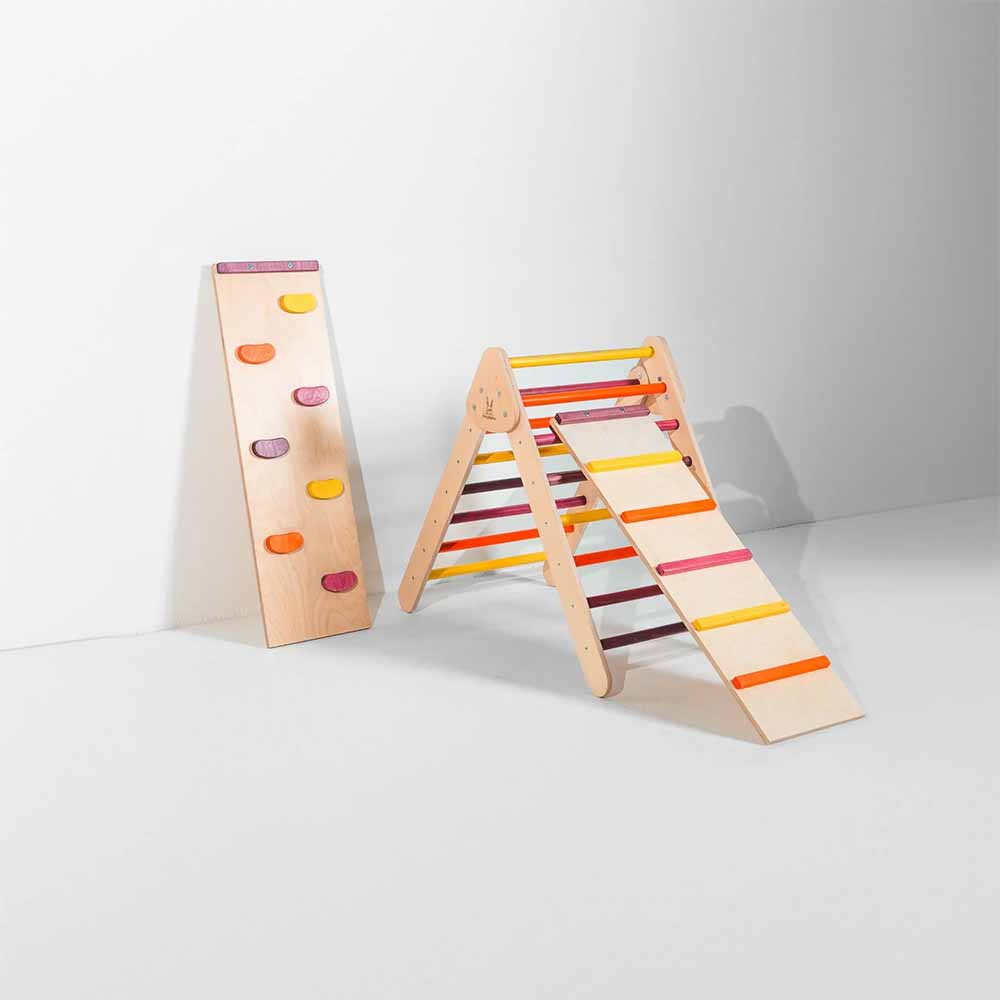 Colorful wooden climbing toy with a ramp and rock wall on a white background