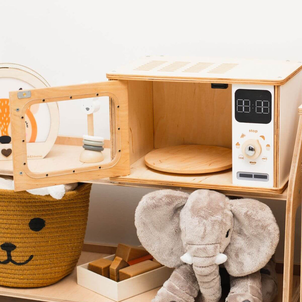 Wooden toy microwave and elephant toy on a white background