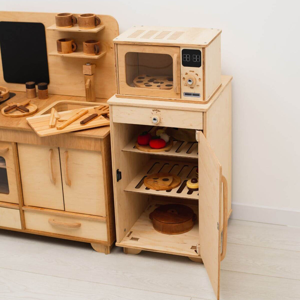 Wooden toy kitchen set with microwave and shelves on a white background