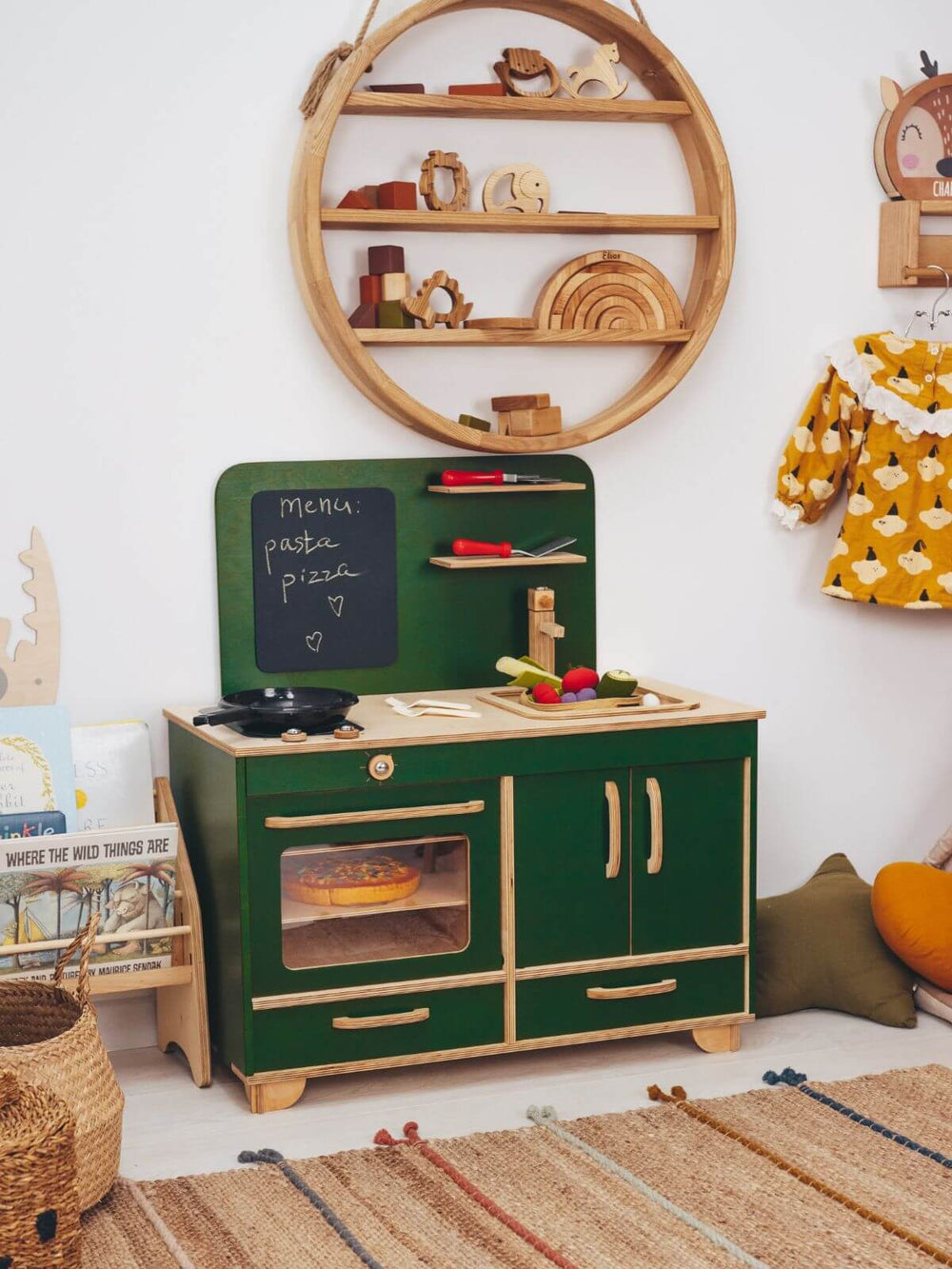 Children's play kitchen set in a room with wooden shelves and decorative items.