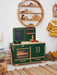 Children's play kitchen set in a room with wooden shelves and decorative items.