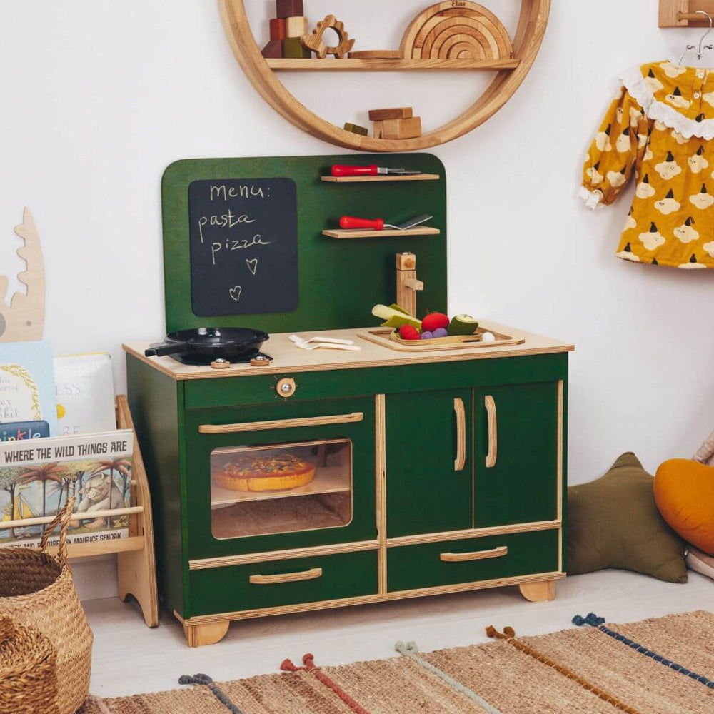 Children's toy kitchen set with green and wooden design in a room setting.