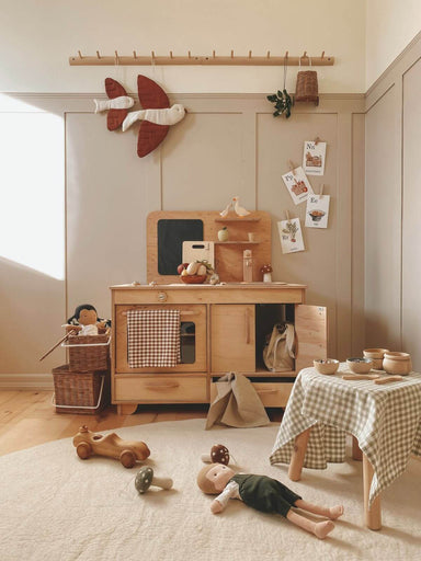 Children's playroom with wooden furniture, toys, and decorative items.