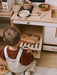 Child playing with a wooden play kitchen set