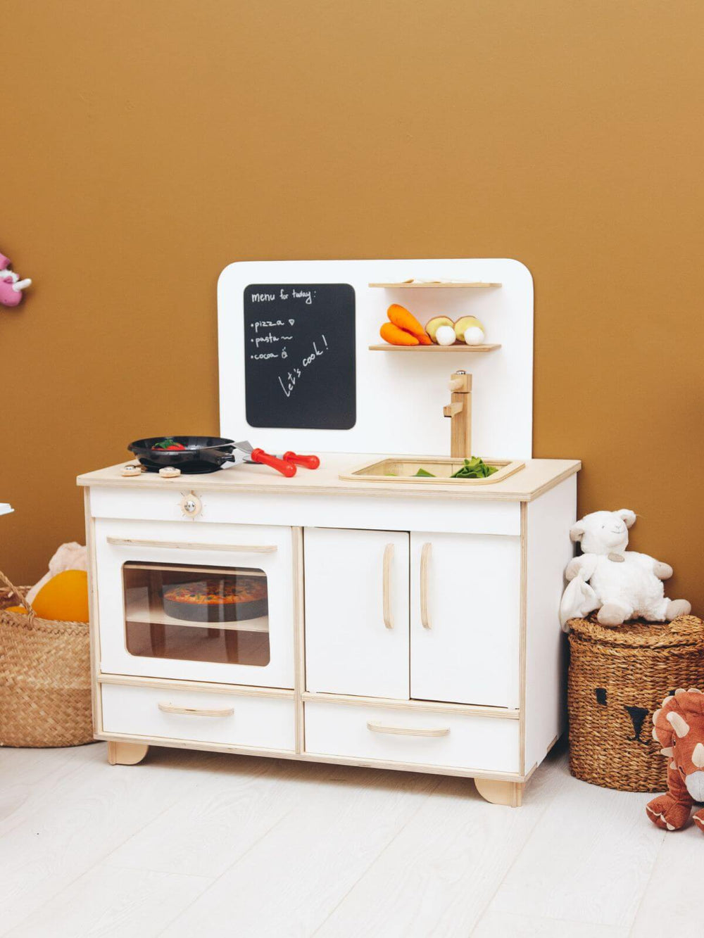 Children's play kitchen set with toys on a beige background