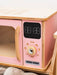 Pink toy microwave oven with wooden frame and digital display on a white background