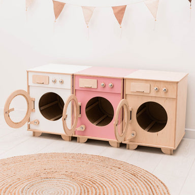 Wooden toy washing machine set on a white floor with a woven rug.