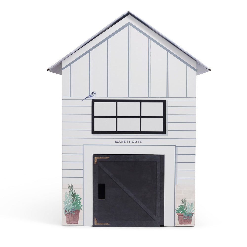 White toy barn with black door and window on a white background