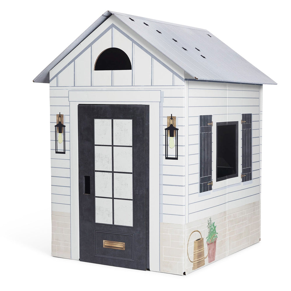 Playhouse with white siding, black door, and decorative elements on a white background