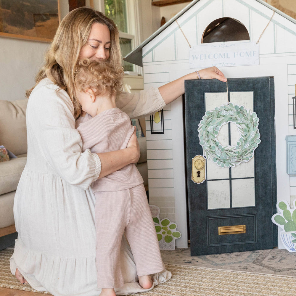 Woman and child interacting with a playhouse