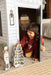 Child playing with a cardboard playhouse in a bedroom