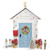 Decorative playhouse of Santa's Workshop with a blue door, wreath, and Christmas decorations.