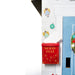 Decorative mailbox with 'North Pole' text on a white wall with Christmas-themed decorations.