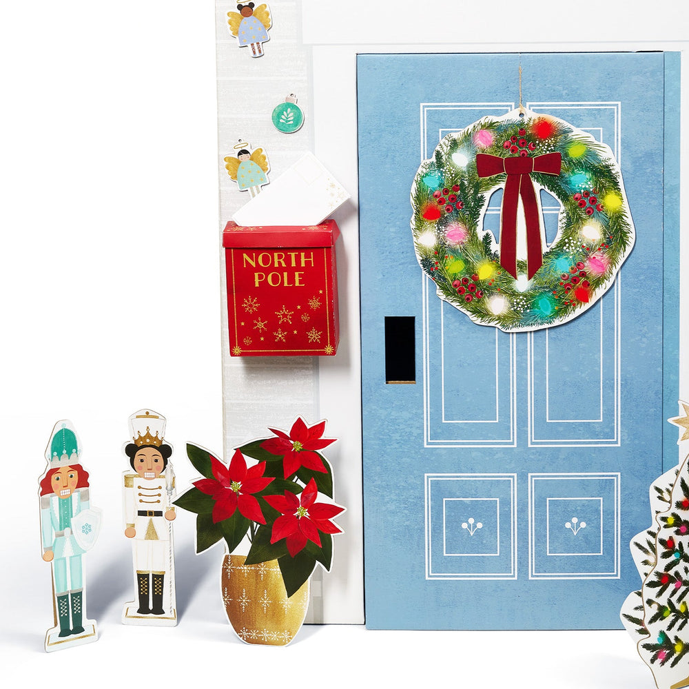 Christmas-themed door with wreath, poinsettia, and decorative figures on a white background