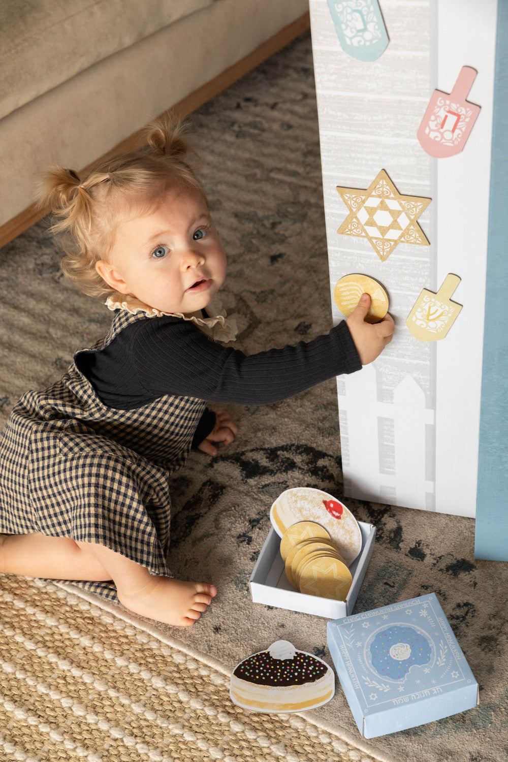 Child playing with a play house set on a carpeted floor