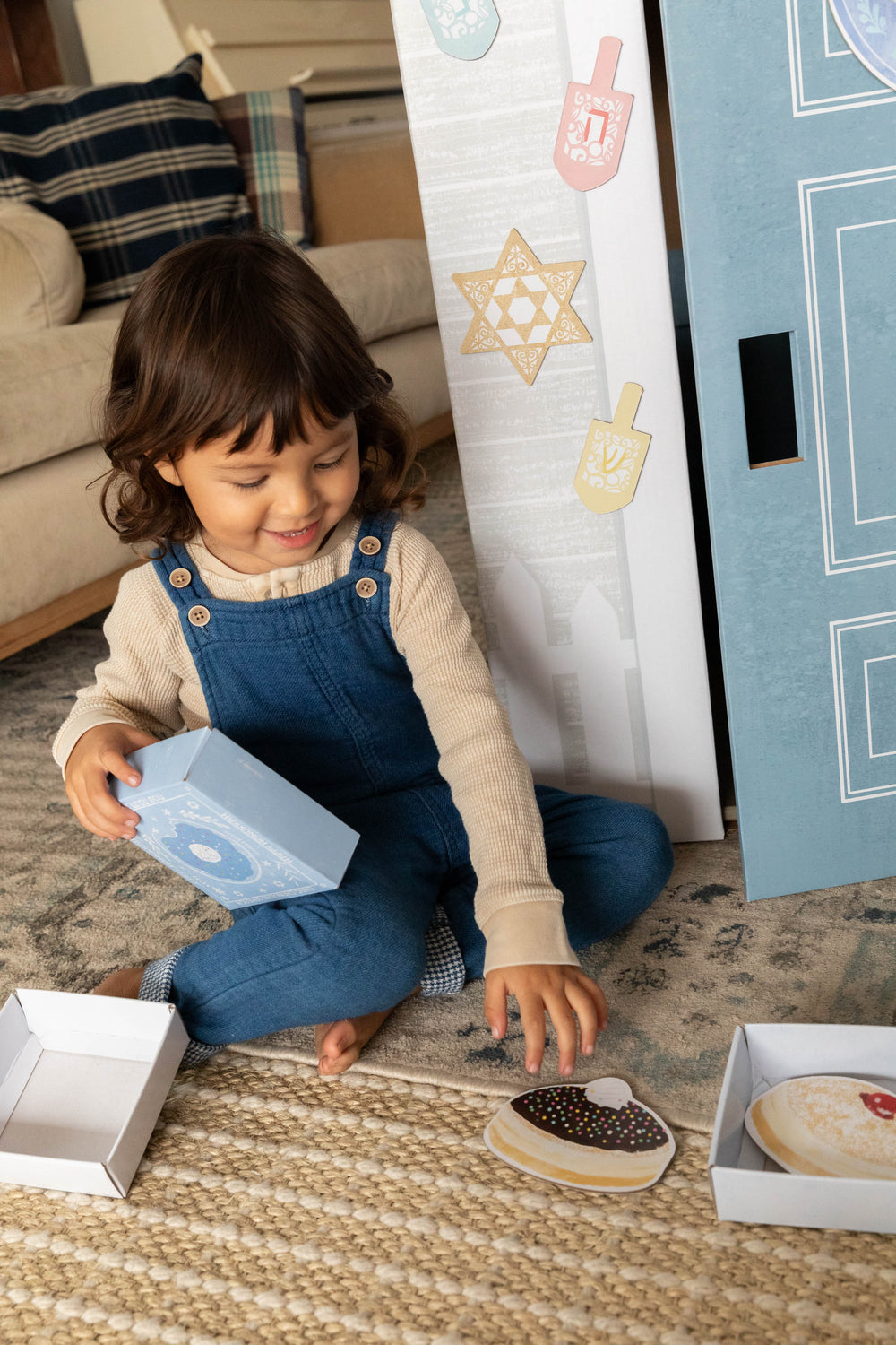 Child playing with cookie-shaped toys on a carpeted floor