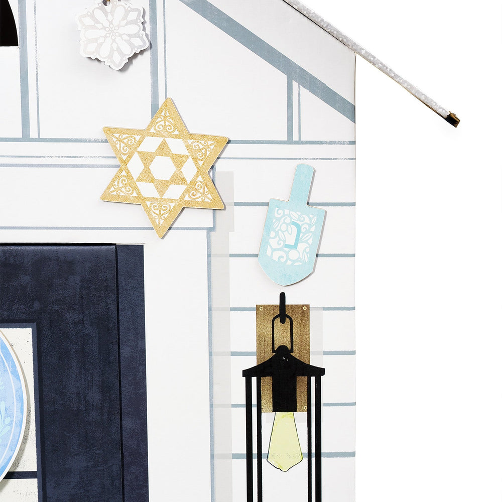 Decorative items including a Star of David, a dreidel, and a lantern on a white playhouse wall with blue horizontal stripes.