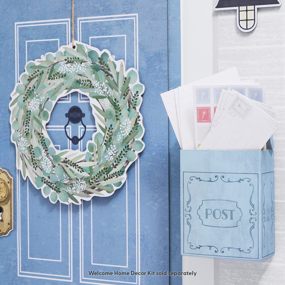 Decorative wreath on a door with a mailbox containing letters, against a blue wall.