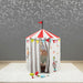 Children's play tent with circus design on a gray floor.