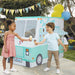 Two children holding ice cream cones in front of an ice cream truck play tent
