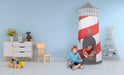 Children playing inside a red and white lighthouse-shaped playhouse in a room with toys and furniture.
