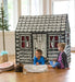Children playing inside a log cabin play house with black and white design.