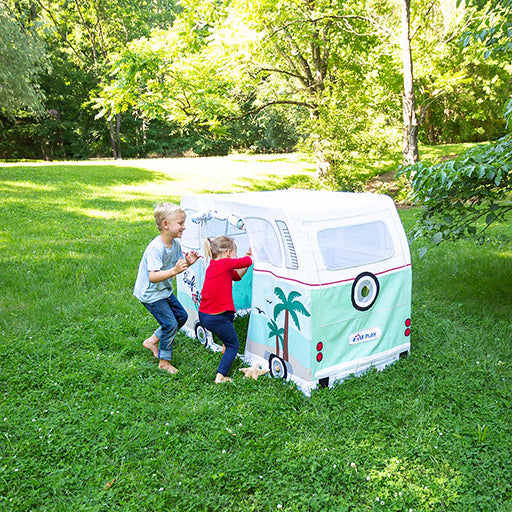 Two children playing with a vintage-style camper tent in a park.