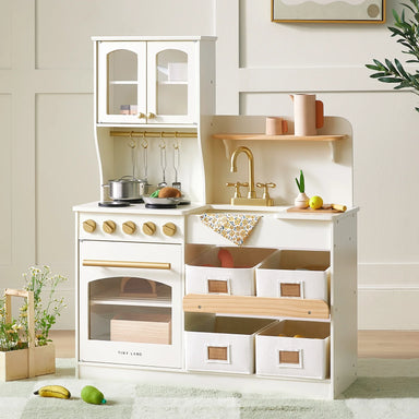 Children's play kitchen set with white stove and wooden shelves in a room.