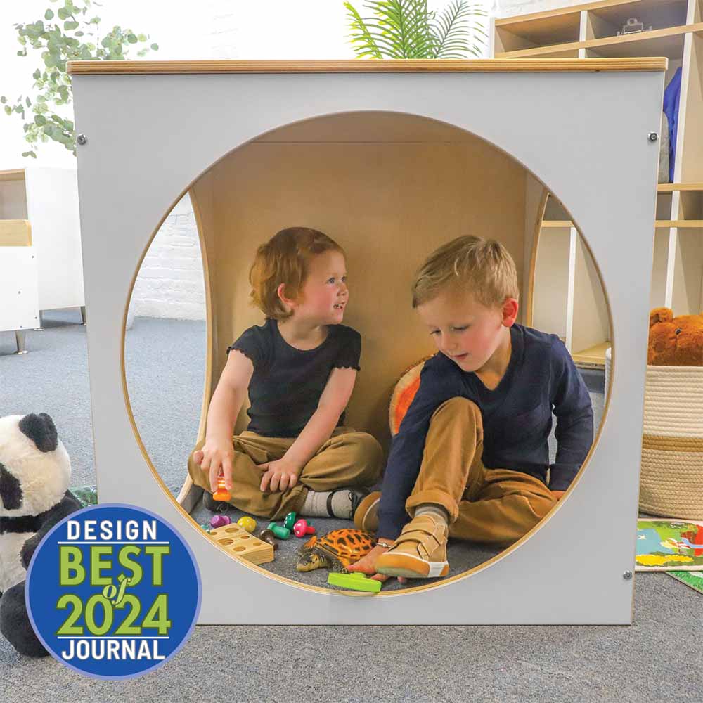 Two children playing with toys inside a play cube, with 'Design Best 2024 Journal' badge on the left.