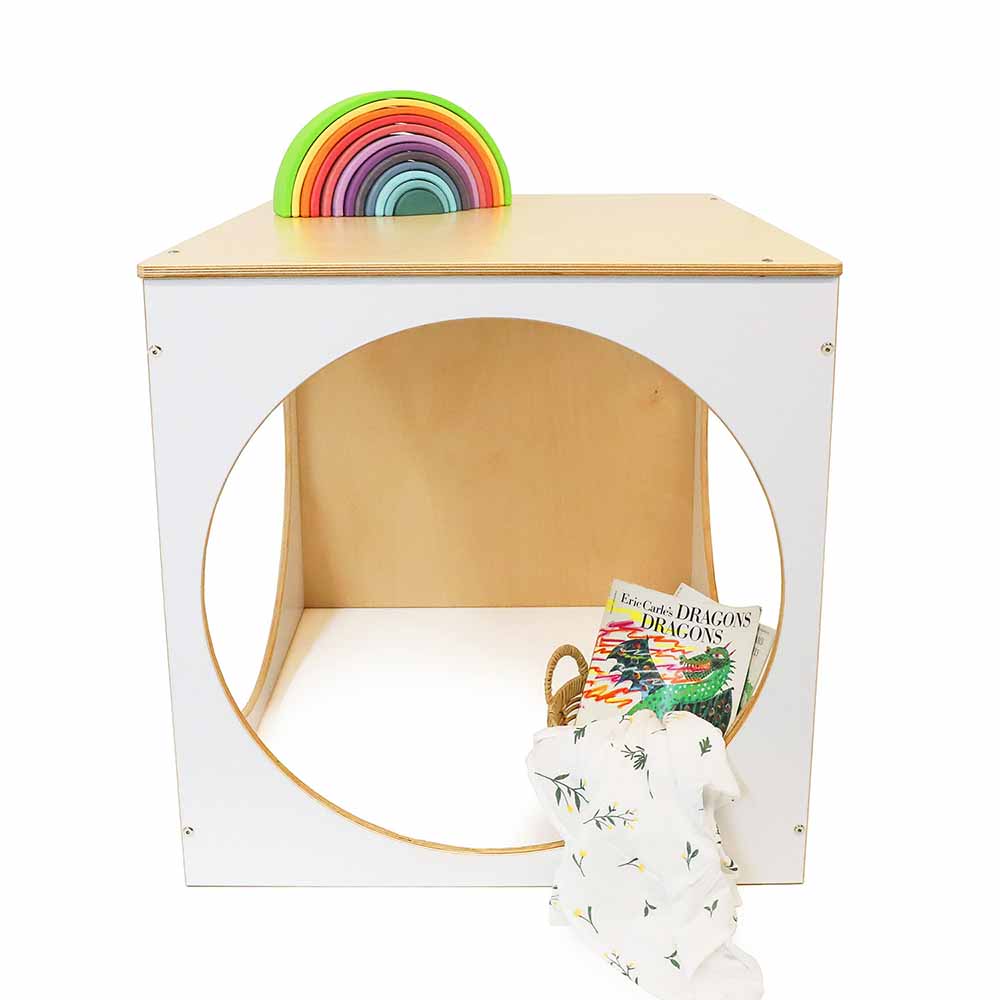 Children's play cube with rainbow discs, books, and a blanket on a white background