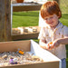 Child playing with toys in a big and wide table outdoors